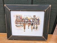 Full view of framed artwork showing vintage fishing lures painted in watercolor hung on wooden rack