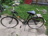 Side view of green vintage Raleigh bicycle with child's seat on rear rack