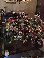 Overview of multiple resin flower stems displayed in clear glass vases on dining table