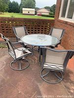 Full set of patio table with 4 chairs on concrete patio showing general condition and arrangement.