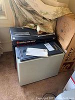 Fire safe deposit box with original box and fabric material around it in a room corner