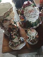 Four Fitz & Floyd Christmas Santa pieces and scalloped planter on wooden table