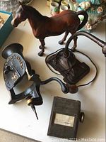 Overall photo showing the die cast horse figurine, vintage metal desk lamp, cast iron No.1 Patent tool, and metal address file on the table.