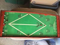 Top view of the vintage green baseball game board with white diamond field and wooden frame.