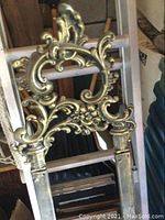 Close-up of top decorative scrollwork crest