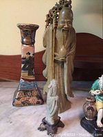 Tall carved longevity figure and square porcelain vase with small celadon resin figurine