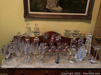 Full display of assorted crystal and glassware on marble surface