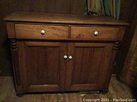 Front view of cabinet showing two upper drawers and two lower doors with turned side columns