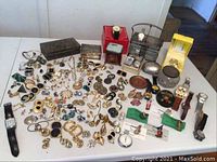 Full lot view on white table showing jewelry, watches and boxes