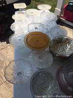 Overall view of collection of clear and amber glass serving pieces on table