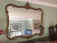 Full front view of large ornate mirror mounted on wall