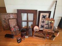 Full view of lot including various used decorative tins, framed pictures, glass jars, wooden window-style mirror frame, and small wooden decor pieces
