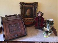 Framed portrait, porcelain doll, ceramic pitchers and antique wooden letter box on marble topped table