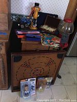 Wide view of various vintage items grouped including Mr. Peanut figurine, bubble gum machine, game board, board games, and comics.