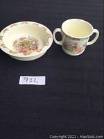 Porridge bowl and two-handled mug overview on black fabric background.