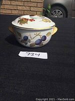 Photo of Royal Worcester small casserole with lid, decorated with plums and leaves, gold-accented handles.