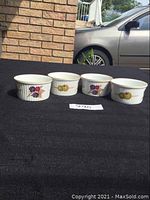 Four Royal Worcester ramekins displayed side by side, showing the decorative exterior designs.
