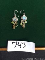 Front view of both earrings showing moonstone, citrine, and peridot gemstones set in sterling silver with ear wires.