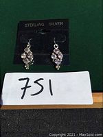 Front view of pair of sterling silver amethyst earrings mounted on a card labeled 'STERLING SILVER'