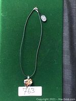 Front view of the heart-shaped Murano glass pendant with gold leaf details, hanging on a black cord necklace with visible silver tag.