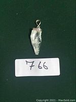 Photo showing clear quartz shard pendant on a dark background with lot number 766.