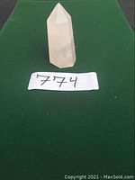 Rose Quartz crystal point standing upright on green felt background with lot number 774 visible.