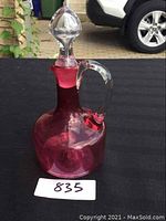 Photo of pink blown glass cruet showing overall shape, handle, and stopper