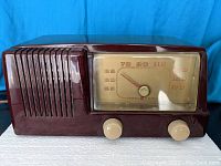 Front view of General Electric tube radio showing large frequency dial, speaker grille, and control knobs.