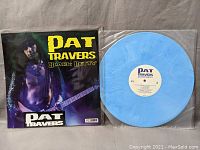 Blue marbled vinyl record with cream label marked Pat Travers Black Betty, alongside original album cover featuring artist with guitar.