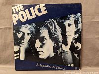 Front cover of The Police Regatta de Blanc album with band photo and album title.