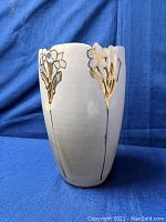 Ceramic vase with floral and gold detailing, front side view showing the full design and shape.