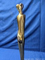 Side view of the signed cast bronze couple sculpture showing the elongated figures and dual-tone finish.