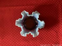 Top view showing the ruffled edge and blue opalescent color.