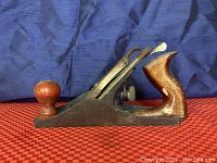 Side view of Great Neck G-4 woodworking hand plane showing wooden knob handle at front and wooden rear handle with metal body.