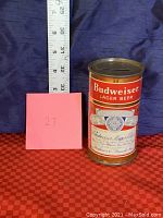 Front view of the Budweiser flat top coin bank with measuring tape showing height about 5 inches.