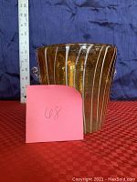 Front side view of the amber Murano glass ice bucket with white spiral design and clear glass handles, showing its size next to a ruler.