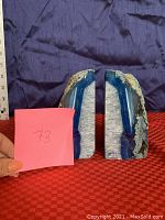 One geode bookend shown standing next to a ruler for size reference and holding a pink note with lot number.
