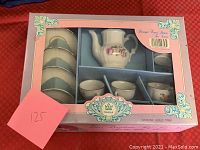 Full boxed tea set for 4 by Royal Kahla in original packaging labeled "Porzellan-Kinder-Service imprimé" with floral decorations and gold trim.