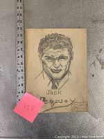 Front view of pencil sketch portrait of Jack Dempsey with measuring ruler placed alongside. Signature 'Philip B.' visible on lower right corner.