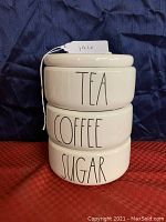 Three stacked ceramic canisters with Tea, Coffee, Sugar labels
