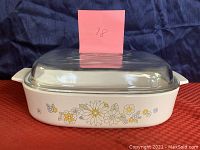 Vintage Corning Ware 2 quart casserole dish in white with yellow and gray floral bouquet design. Rectangular with handles. Original glass lid not included.