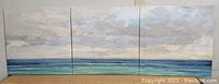 Front view of the three prints together showing the beach and sky scene spanning across them