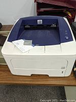 Xerox Phaser 3250 printer on a wooden surface.