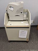 Lexmark Optra M412 laser printer on top of mobile storage stand with caster wheels in closed position