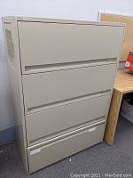 Image of the full front view of the beige metal 4 drawer lateral file cabinet, showing all four drawers closed.
