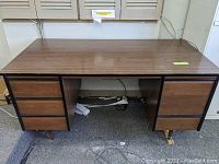 Front and side view of the brown desk showing five drawers and angled wooden legs