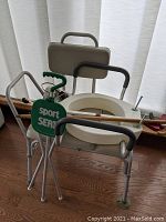 Photo showing bath transfer seat, raised toilet seat with handles, and folding standing seat with green 'Sport Seat' label