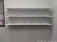 Front view of three white shelves mounted on wall with adjustable metal dividers and metal support brackets.