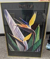 Front view of the framed Birds of Paradise printed poster showing vivid colored flowers and black matte with gold frame.