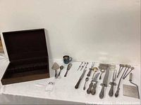 Overall view of felt-lined wooden box and assorted flatware/serving pieces
